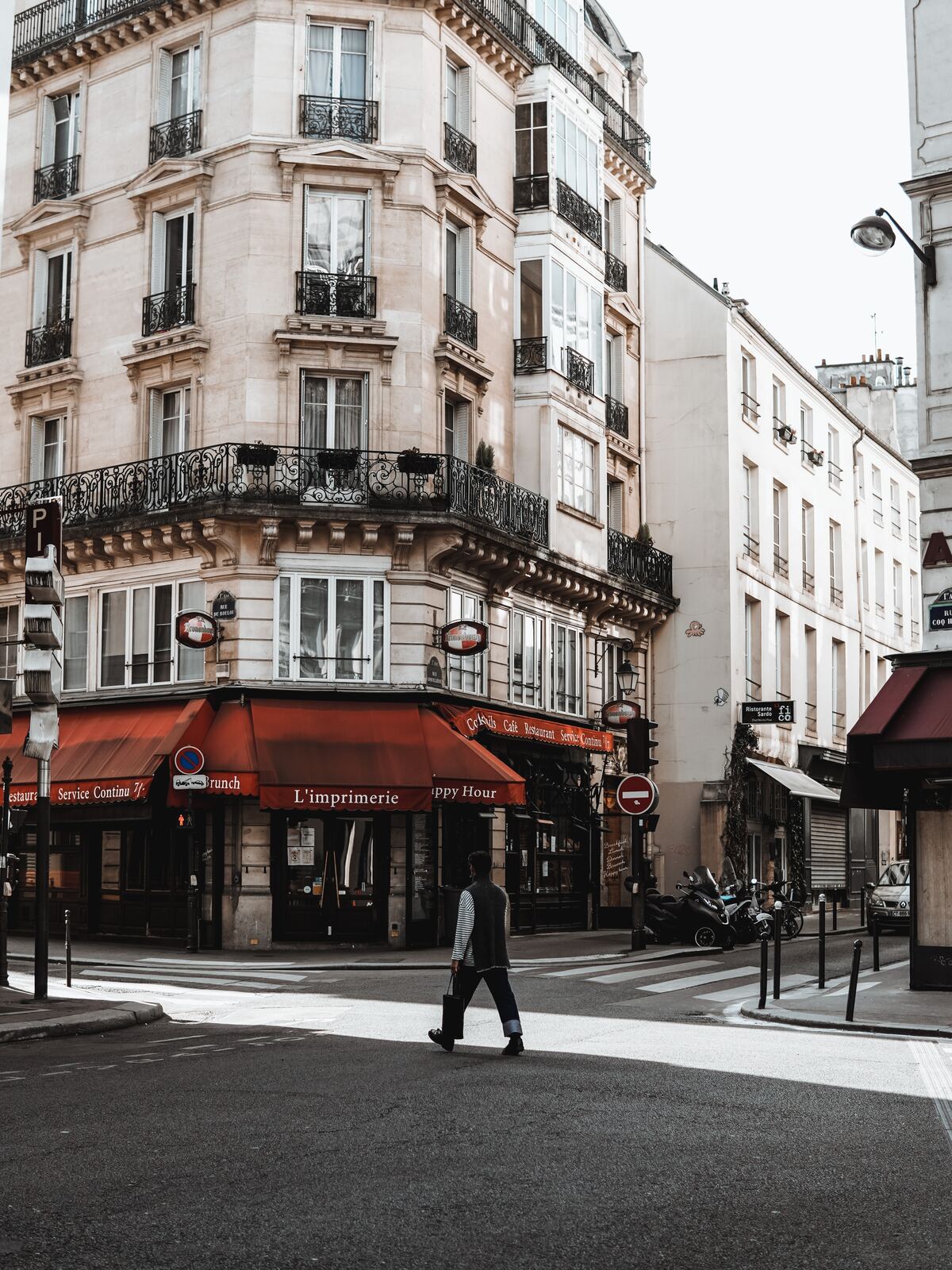 man in black jacket walking on sidewalk near building during daytime