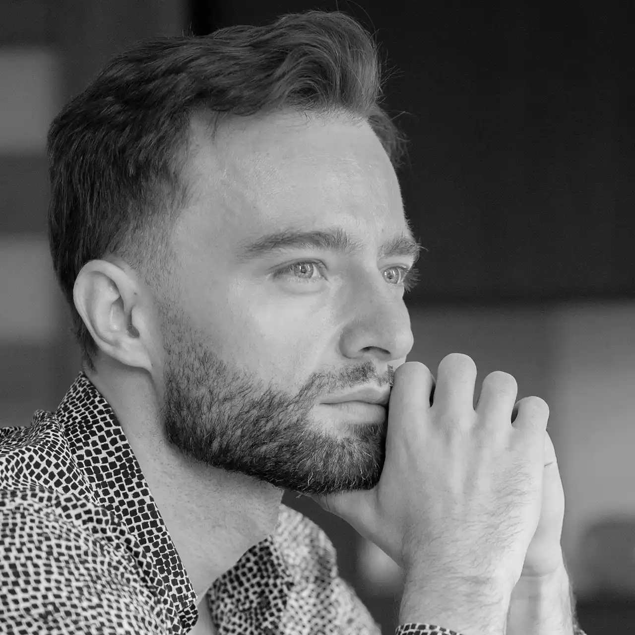 grayscale photography of man touching his leg