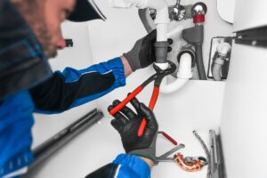 technician examines leaking wall drain