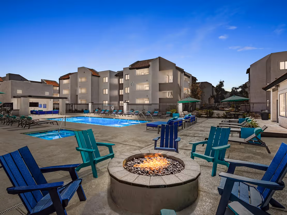 Fire pit with chairs in front of swimming pool
