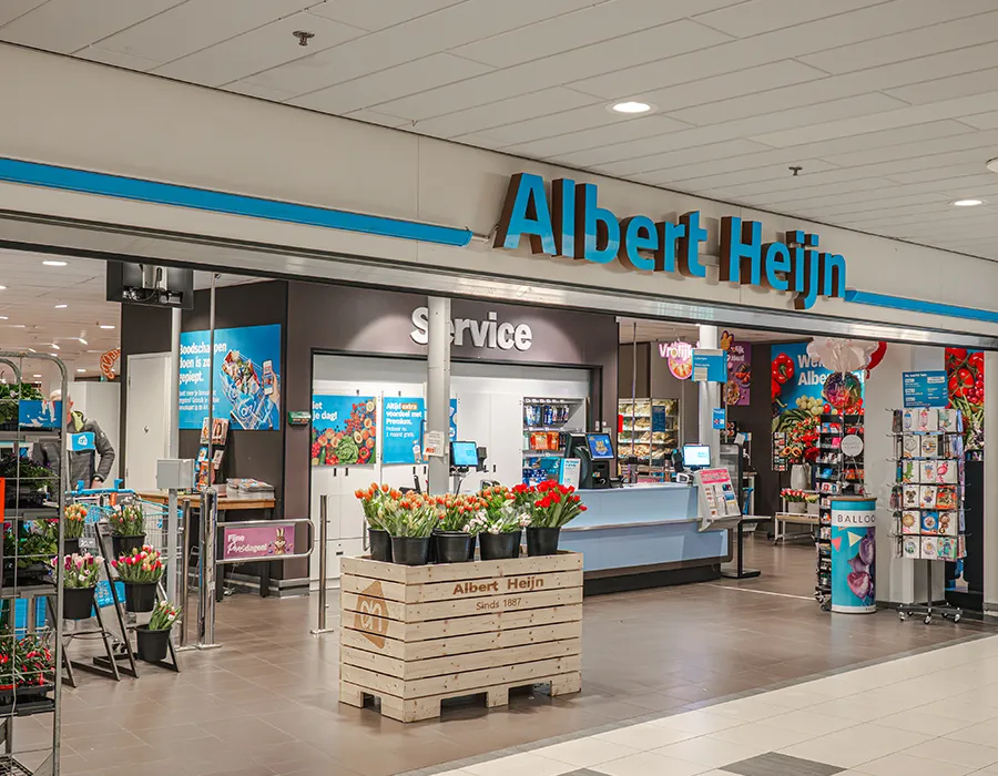 Ingang van Albert Heijn met servicebalie en bloemendisplay