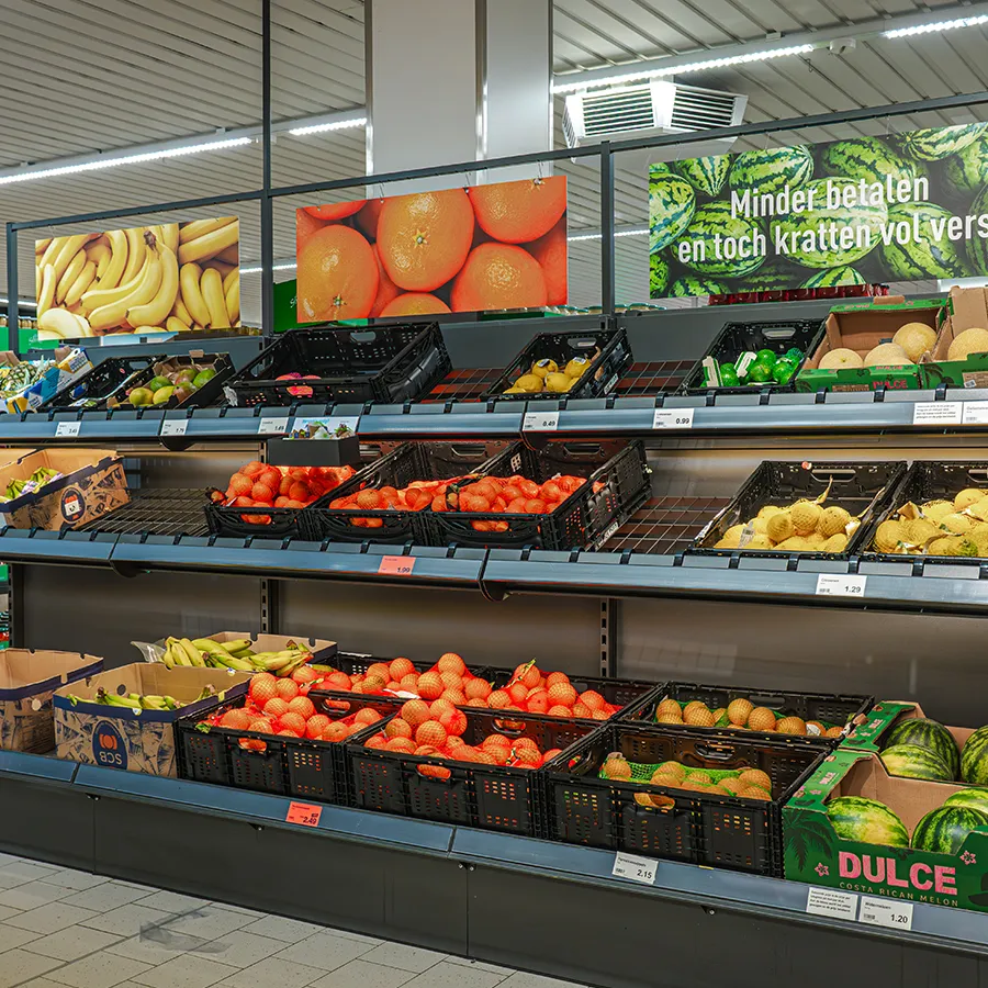 Versafdeling bij Aldi met kratten sinaasappels, meloenen en bananen