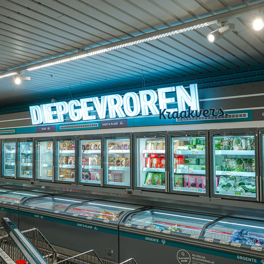 Diepvriesafdeling van Aldi met verlichte vrieskasten en het opschrift 'Diepgevroren Kraakvers'