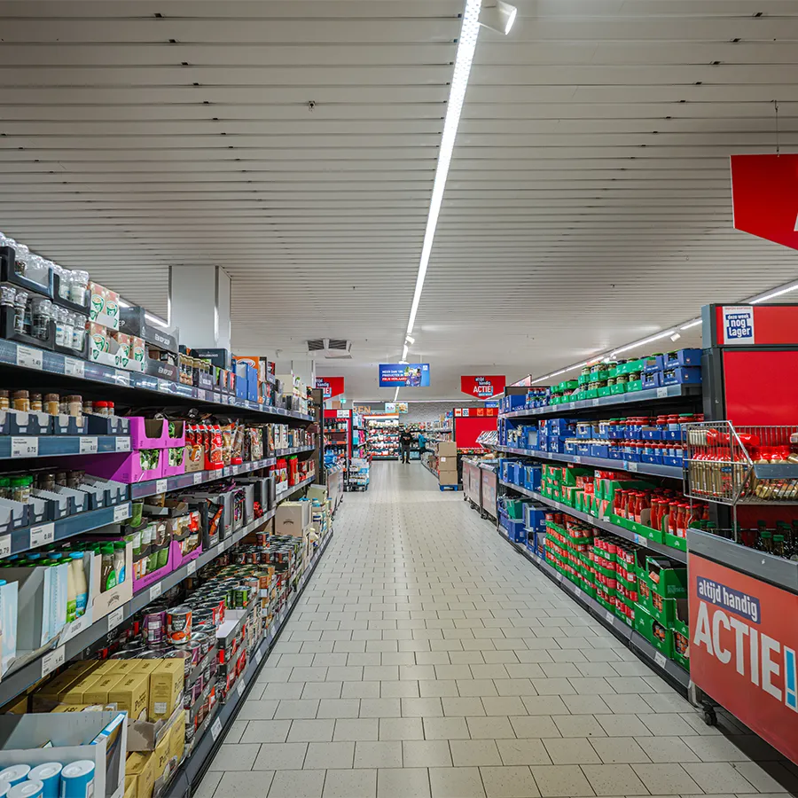 Lang gangpad bij Aldi met sauzen en conserven, met Actie-borden aan het einde
