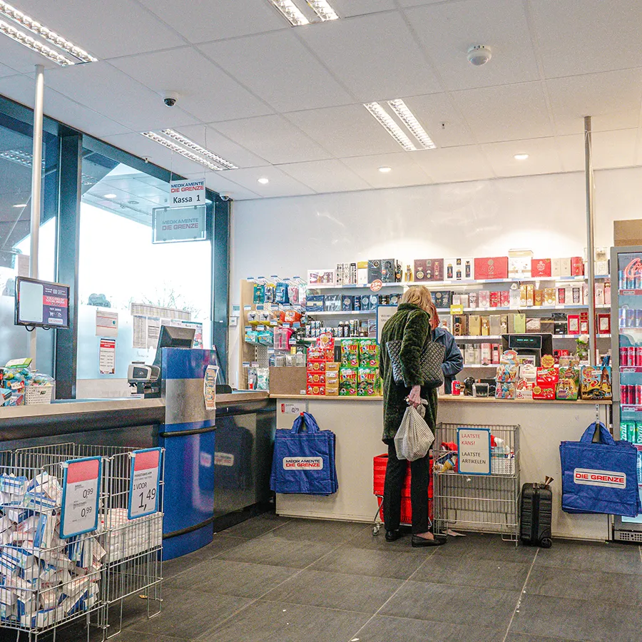 Kassa en servicepunt van Die Grenze in Winkelcentrum Hasselo met klant in beeld