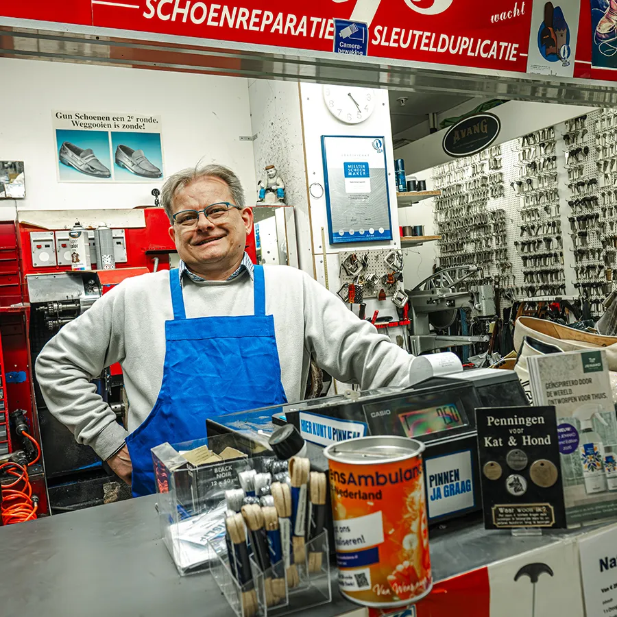 Medewerker achter de balie bij Naafs schoenmakerij in Winkelcentrum Hasselo