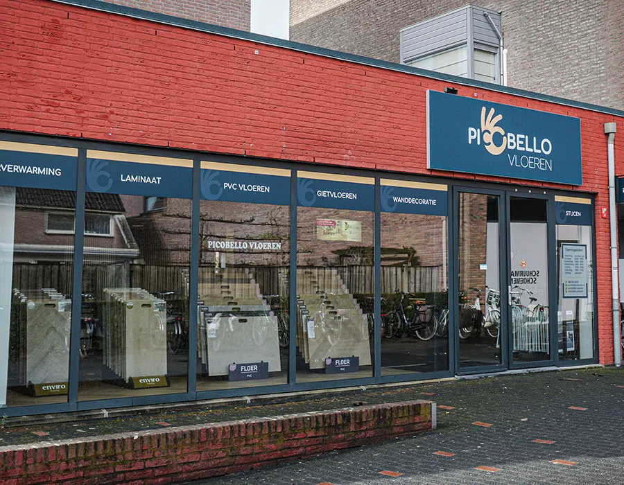 Gevel van Picobello Vloeren in Winkelcentrum Hasselo met etalage en ingang