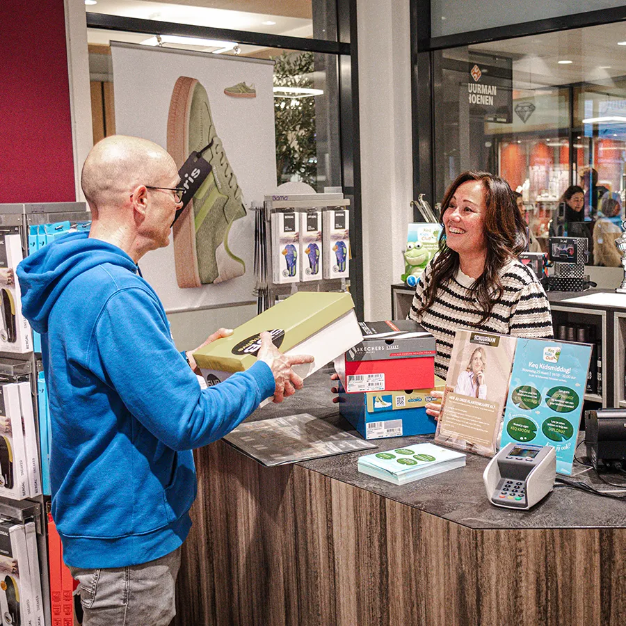 Klant rekent schoenen af bij de balie van Schuurman Schoenen