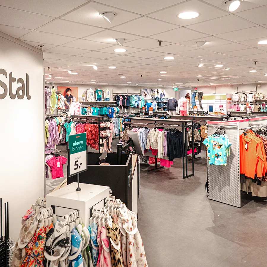 Middenruimte met kledingrekken en aanbiedingen in terStal winkel