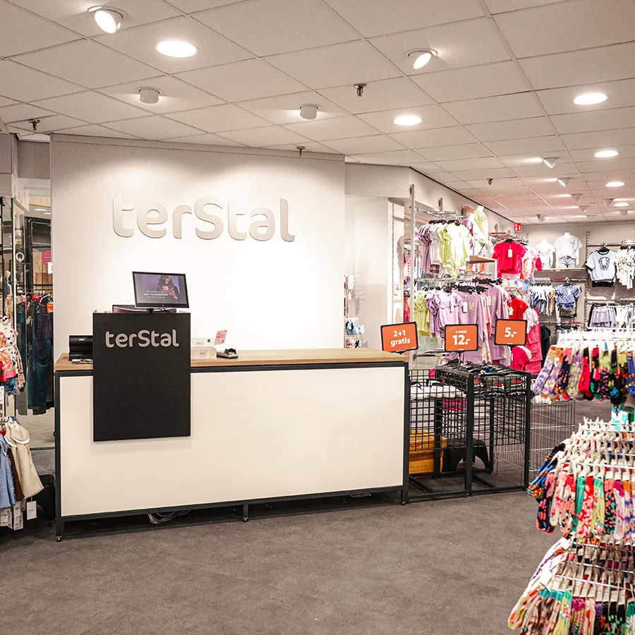 Kassa en balie van terStal winkel met kleding op de achtergrond