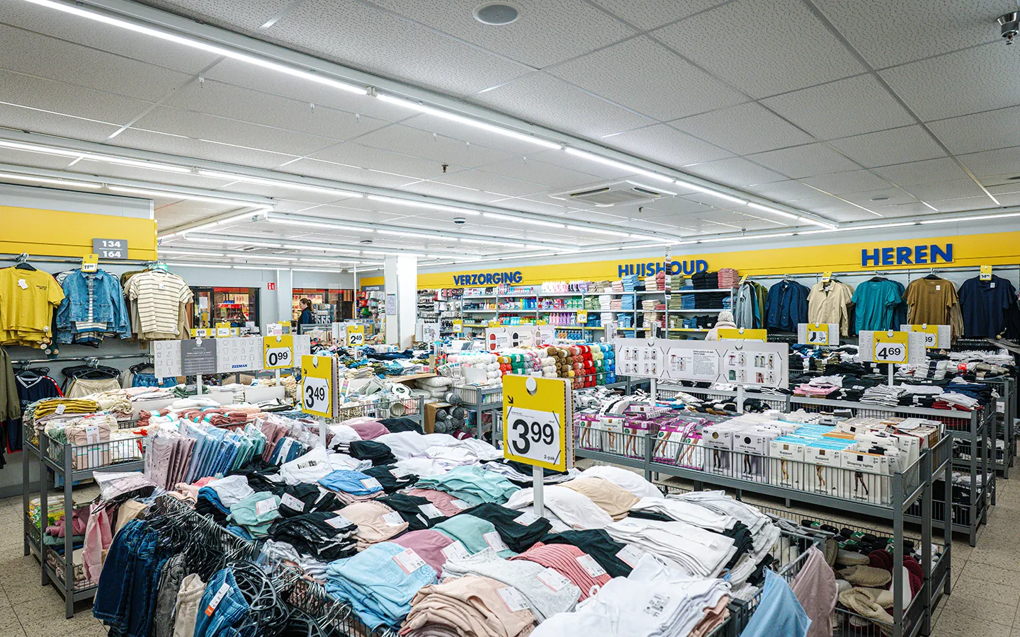 Breed interieuroverzicht van Zeeman in Winkelcentrum Hasselo met afdelingen Verzorging, Huishoud en Heren, gevuld met kleding en huishoudartikelen