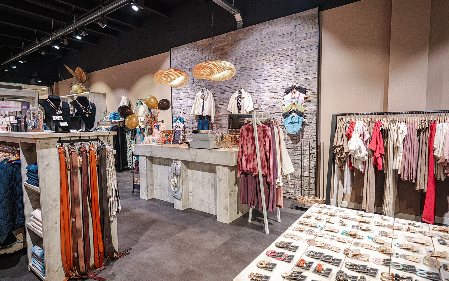 Interieur van ÉlégAnT Mode in Winkelcentrum Hasselo met kassabalie, kledingrekken en een tafel vol sieraden en accessoires