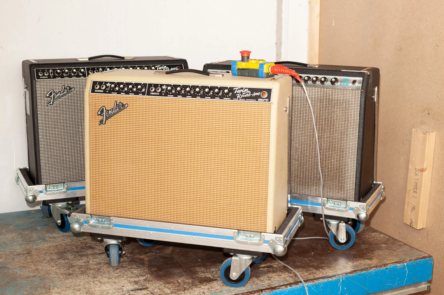 Tre Fender-gitarforsterkere på flightcase-traller, klare til utleie