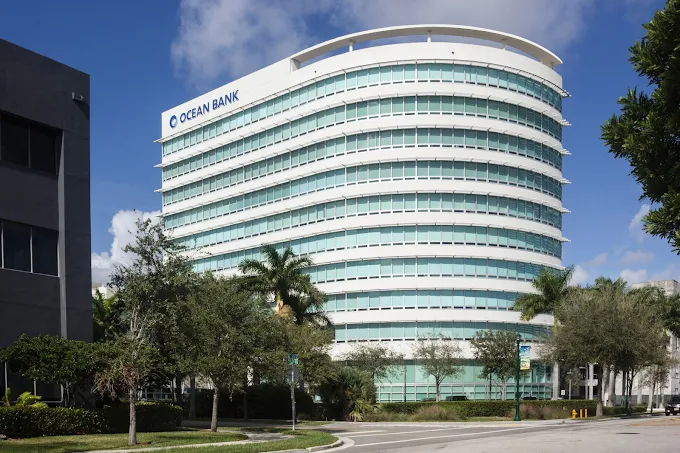Modern multi-story Ocean Bank building with curved facade under a blue sky.