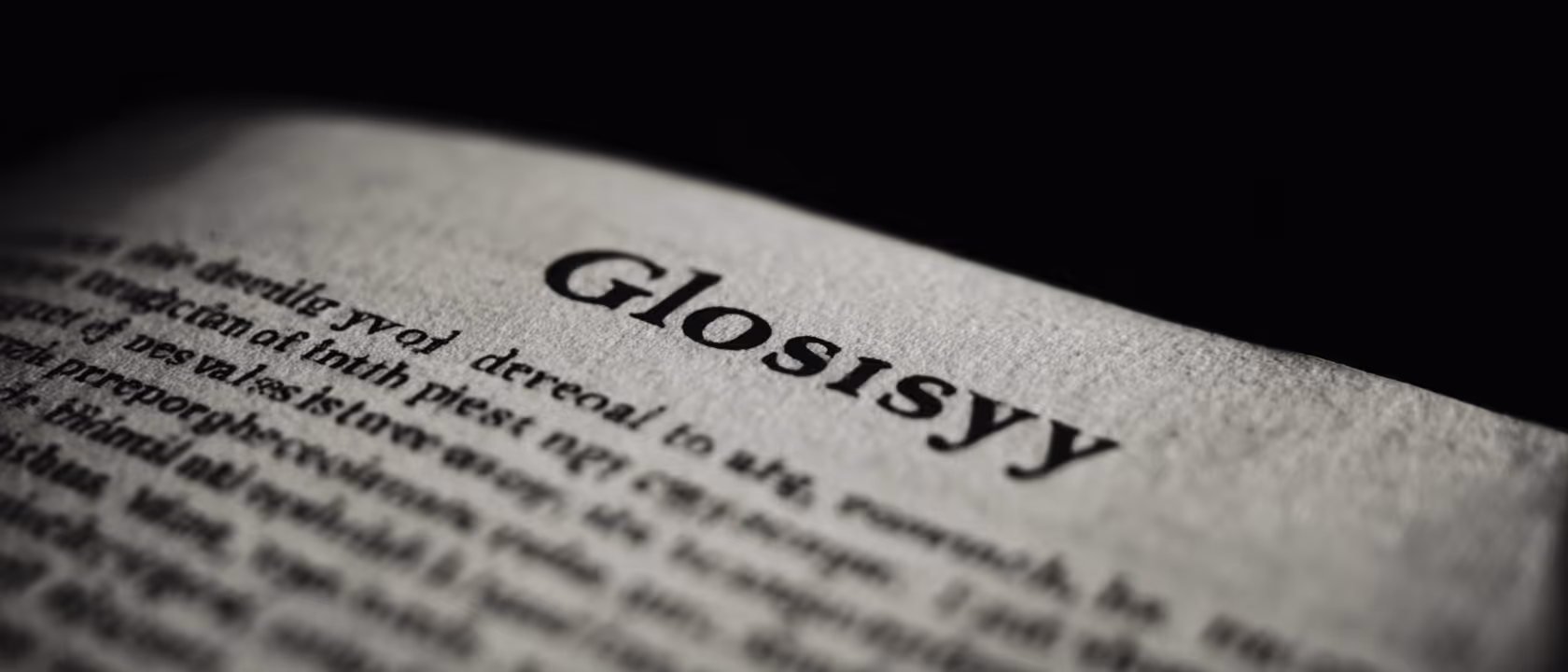 Close-up of a dictionary page showing the word ‘Glosisy’ in bold with surrounding text blurred.