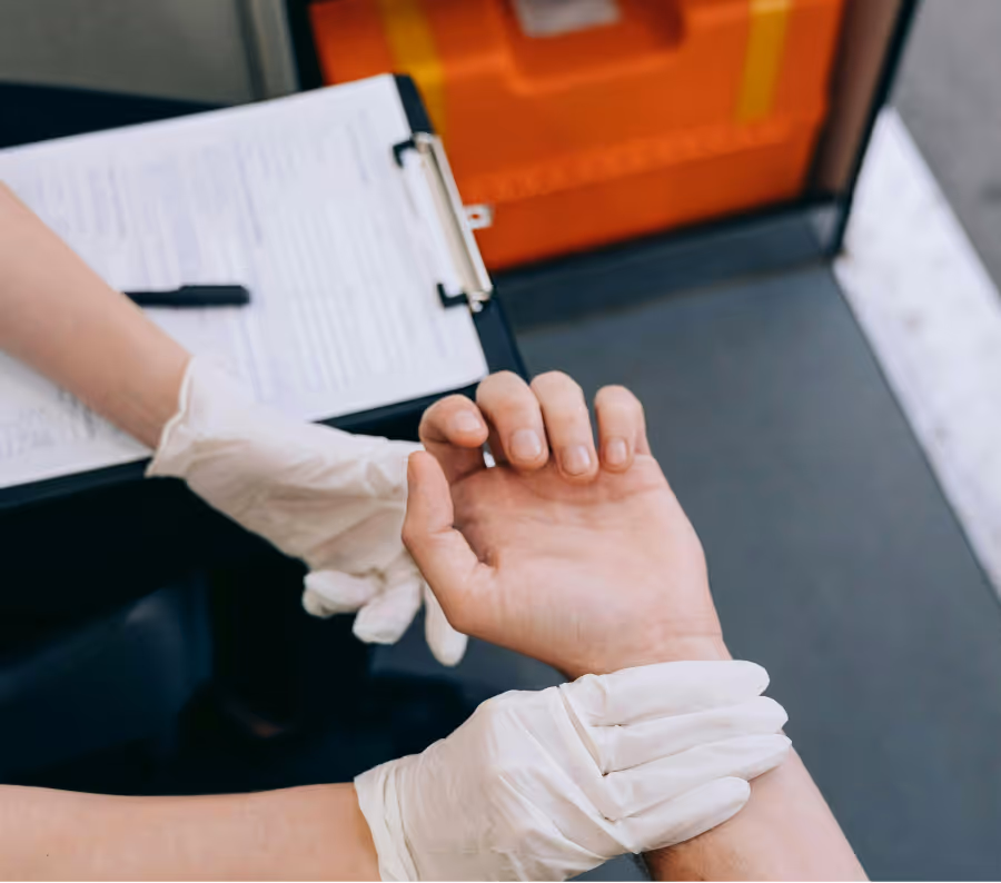 Medical professional wearing white gloves taking a patient's wrist pulse.