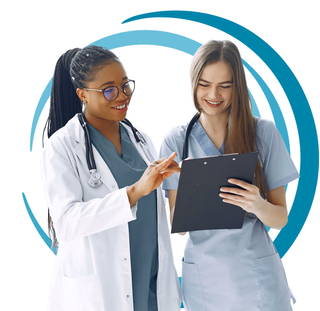 Two female doctors in scrubs and lab coats reviewing a clipboard with smiles.