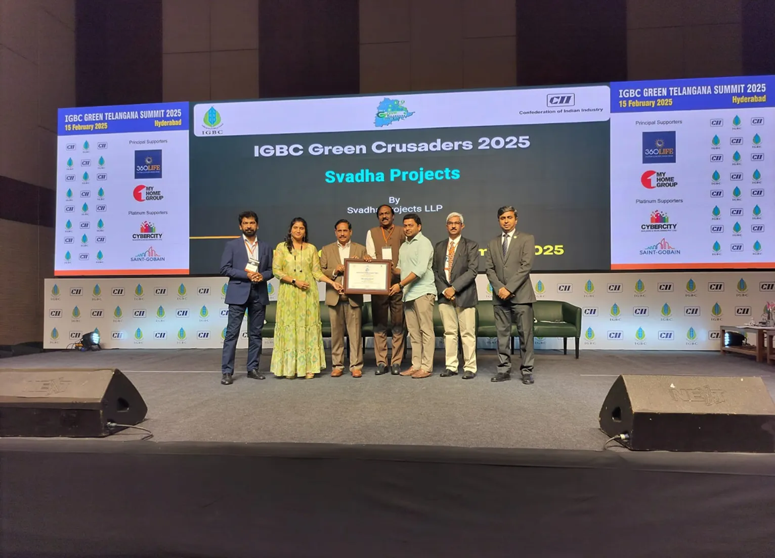 Group of seven people on stage holding an award at IGBC Green Telangana Summit 2025 in Hyderabad.