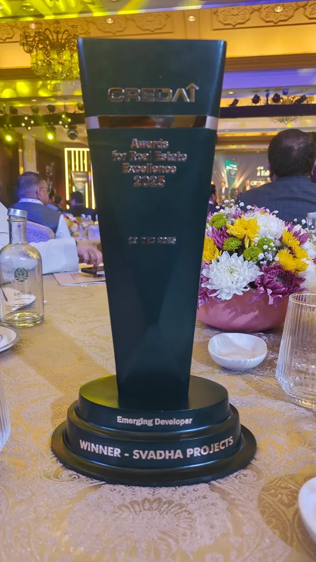 CREDAI award trophy for Real Estate Excellence 2023 for Emerging Developer won by Svadha Projects on a banquet table.