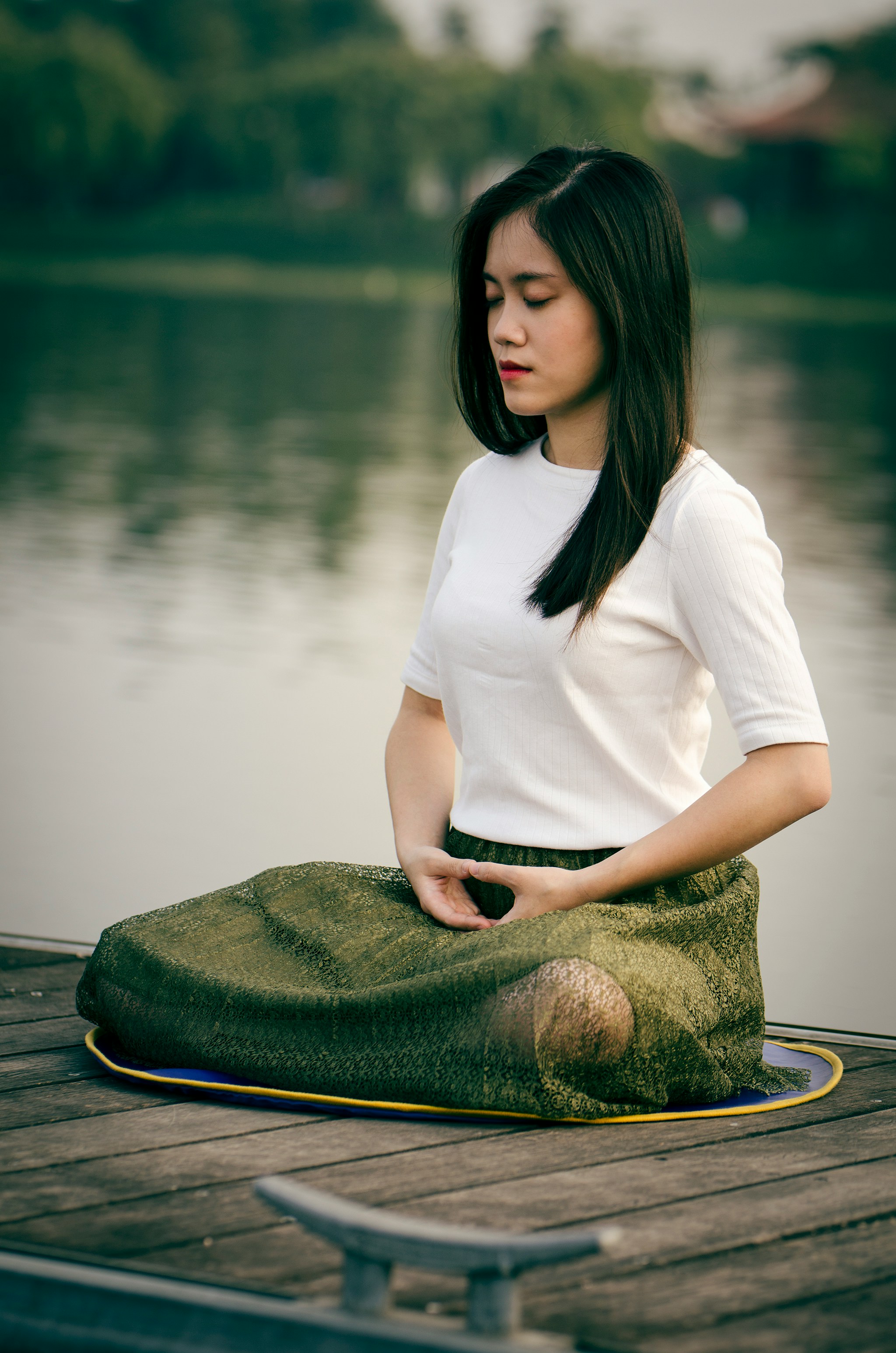 Woman meditating on lake.