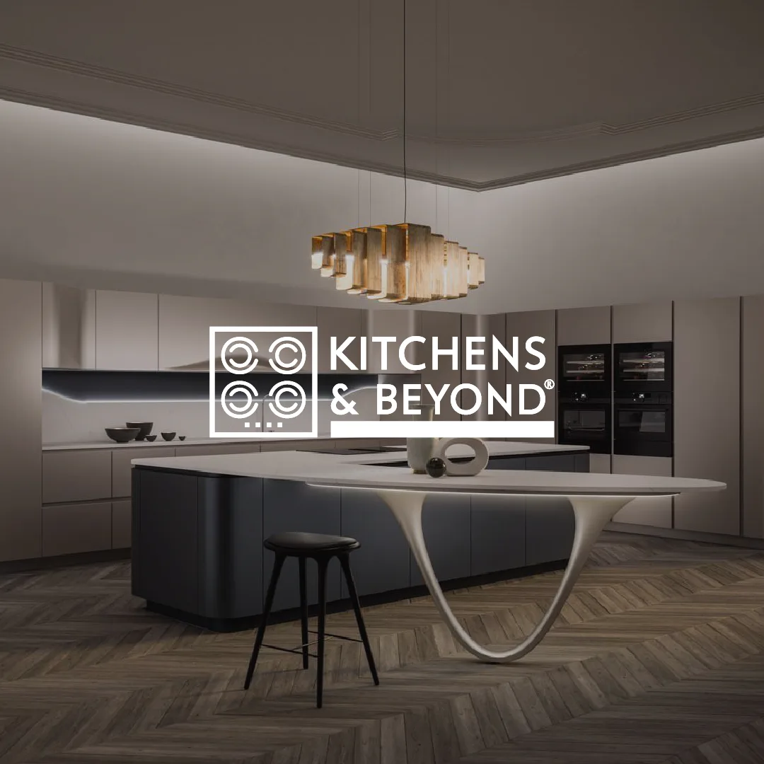 Modern kitchen with a large island, a unique curved white table attached, black stool, and a contemporary chandelier overhead.