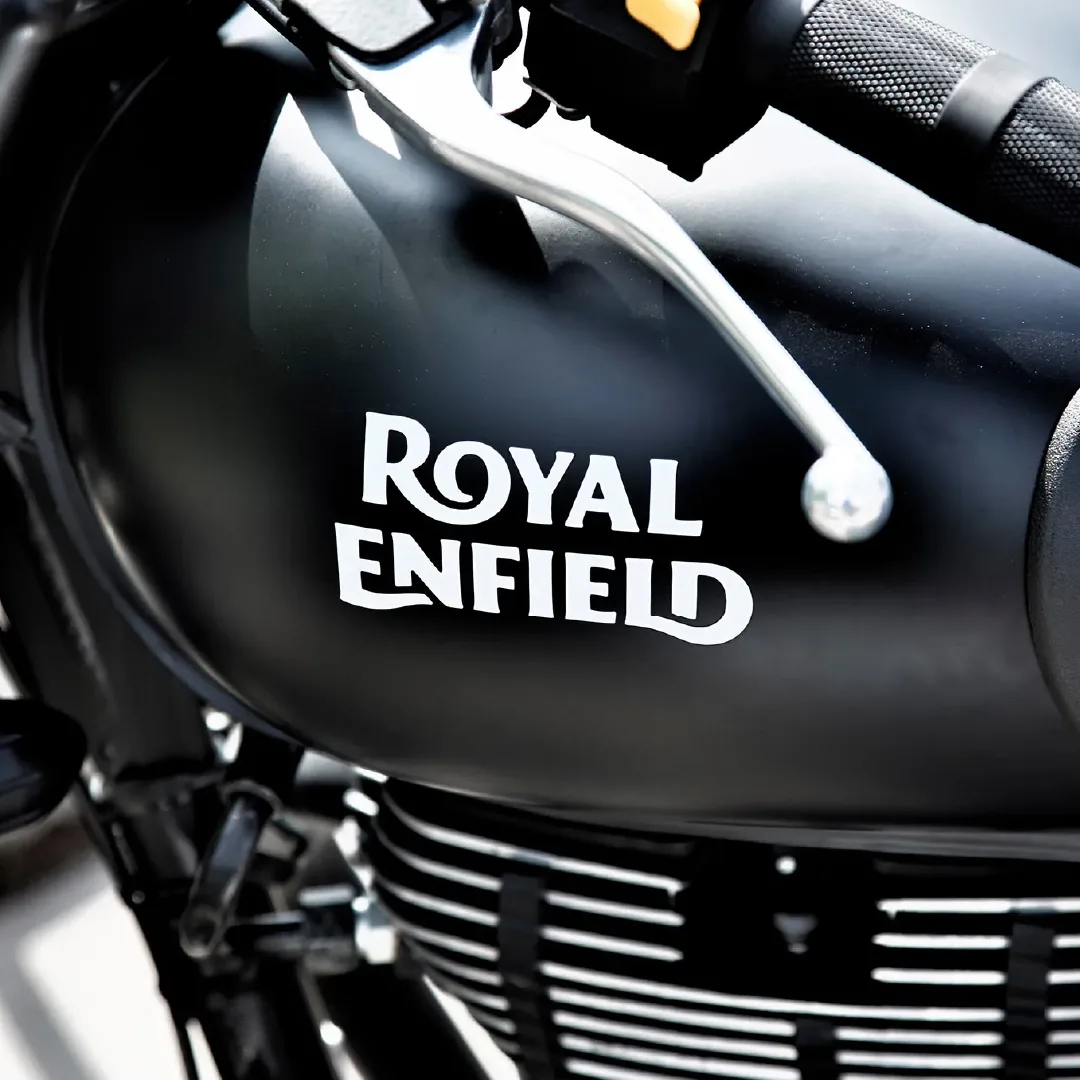 Close-up of a black Royal Enfield motorcycle fuel tank with a silver brake lever and handlebar grip.