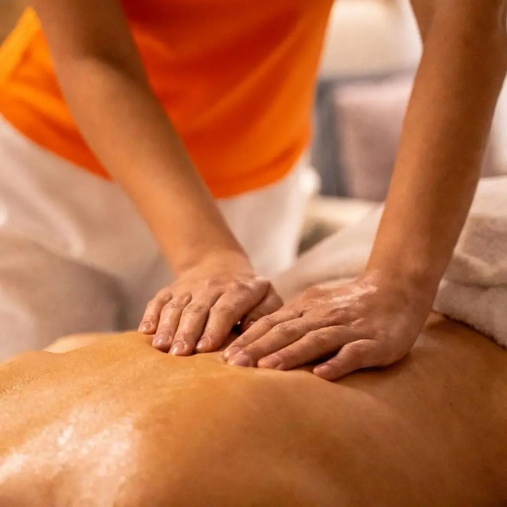 Groupe de personnes portant des masques, faisant des gestes de joie, avec un homme déguisé en Père Noël, dans une pièce décorée.