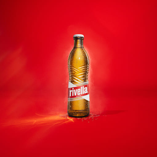 Rivella Rot Glasflasche auf rotem Hintergrund