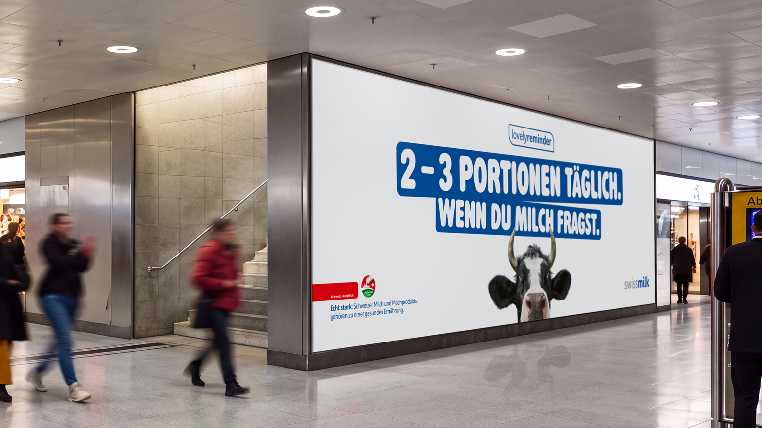 Swissmilk DOOH-Screen in einer Bahnhofspassage mit dem Sujet «2–3 Portionen täglich. Wenn du Milch fragst.» und der Kuh Lovely