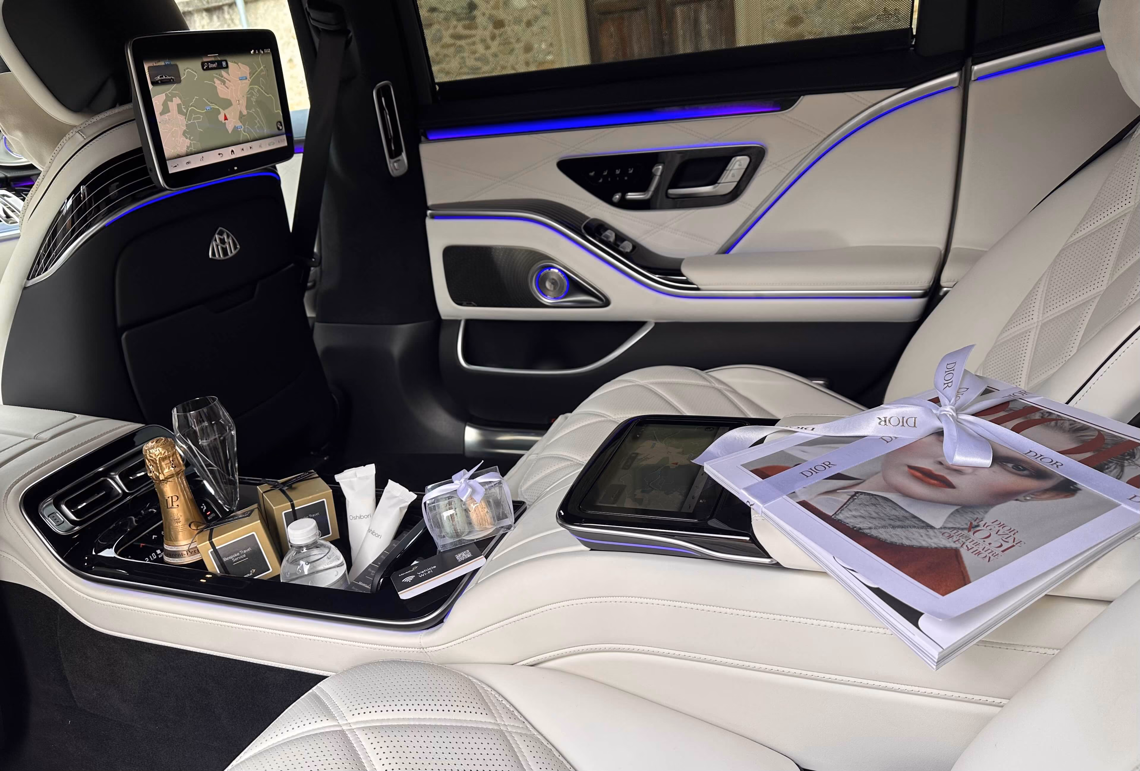 Rear lounge comfort inside the Mercedes Maybach S-Class with premium amenities and white leather seats