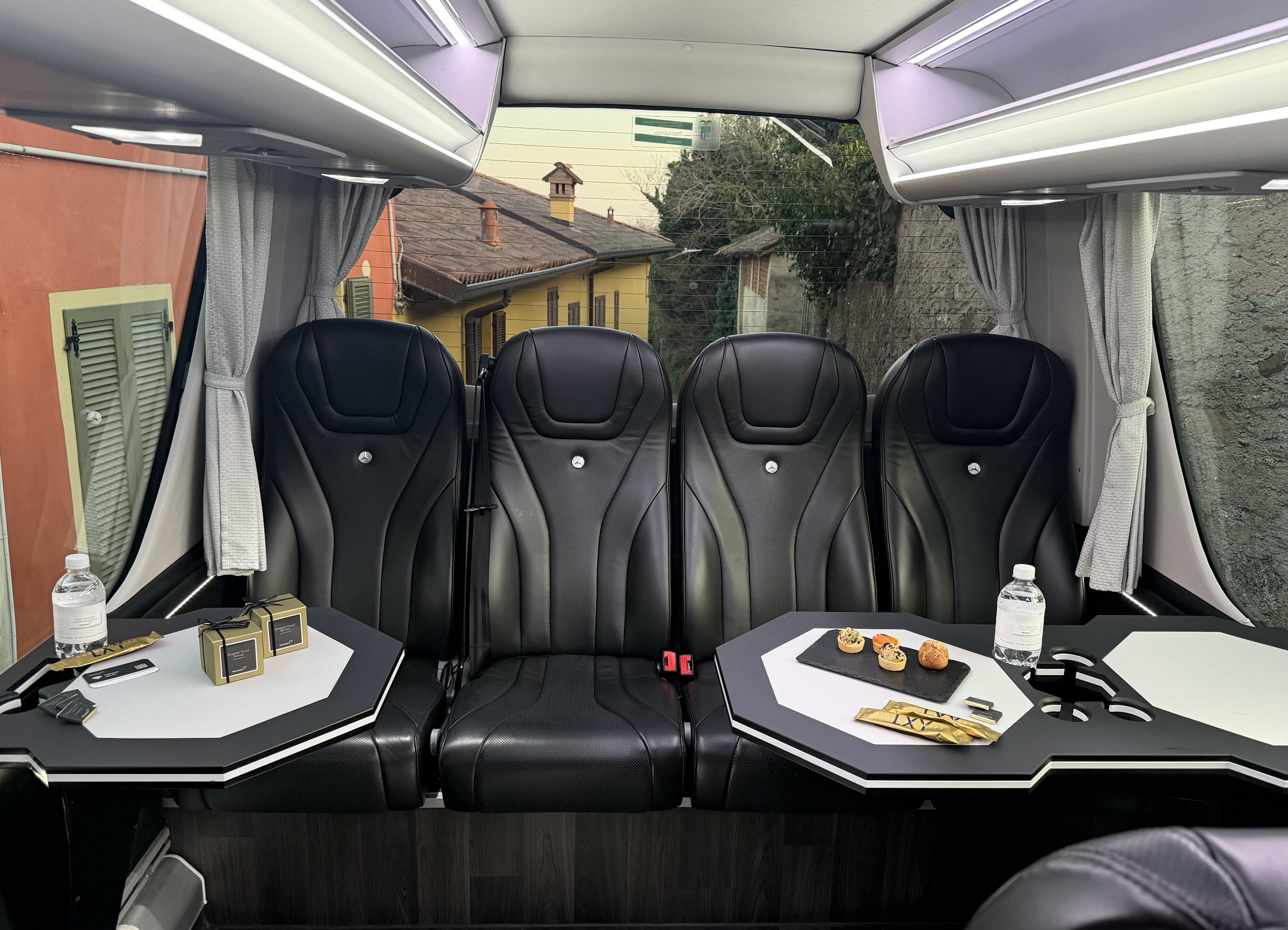 Lounge seat layout inside the Moveolux Luxury Minibus 16 with table and onboard amenities