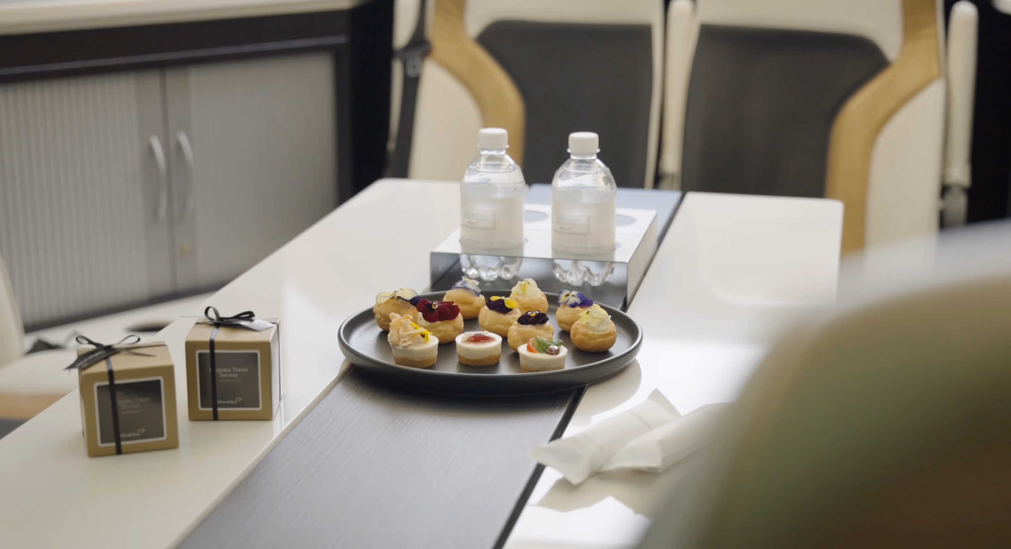 Refreshments table detail inside the Moveolux Limobus Individuals 28 with snacks and water