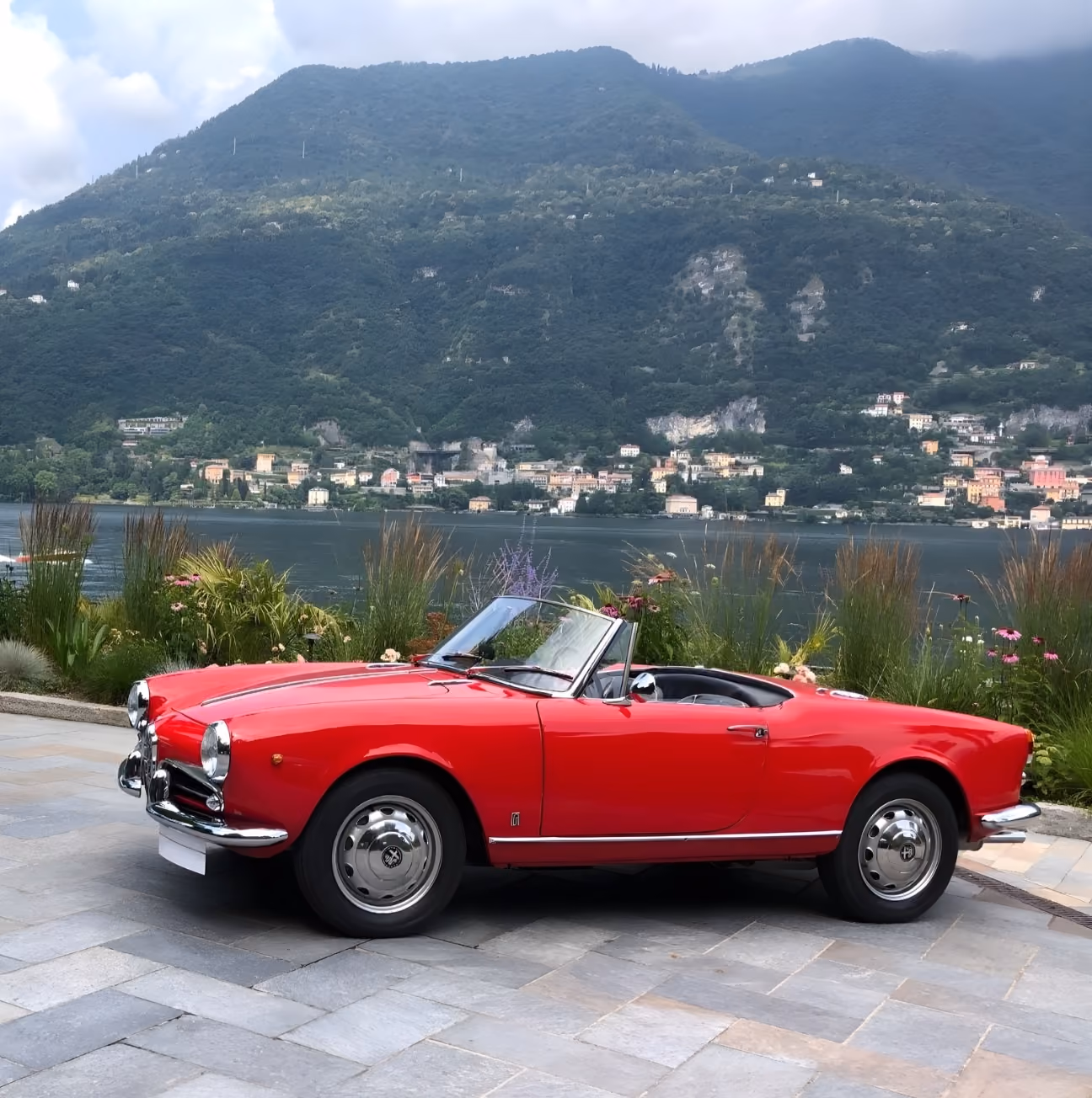 Side profile of the red Alfa Romeo Giulietta Spider overlooking Lake Como