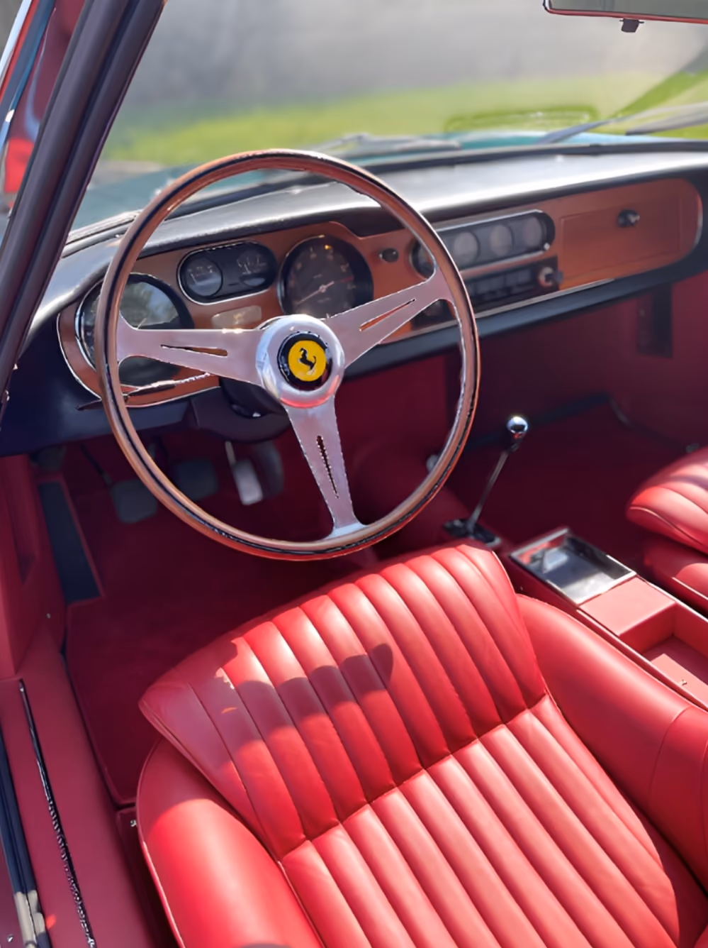 Classic interior dashboard of the Ferrari 275 GTB with steering wheel and red leather seats