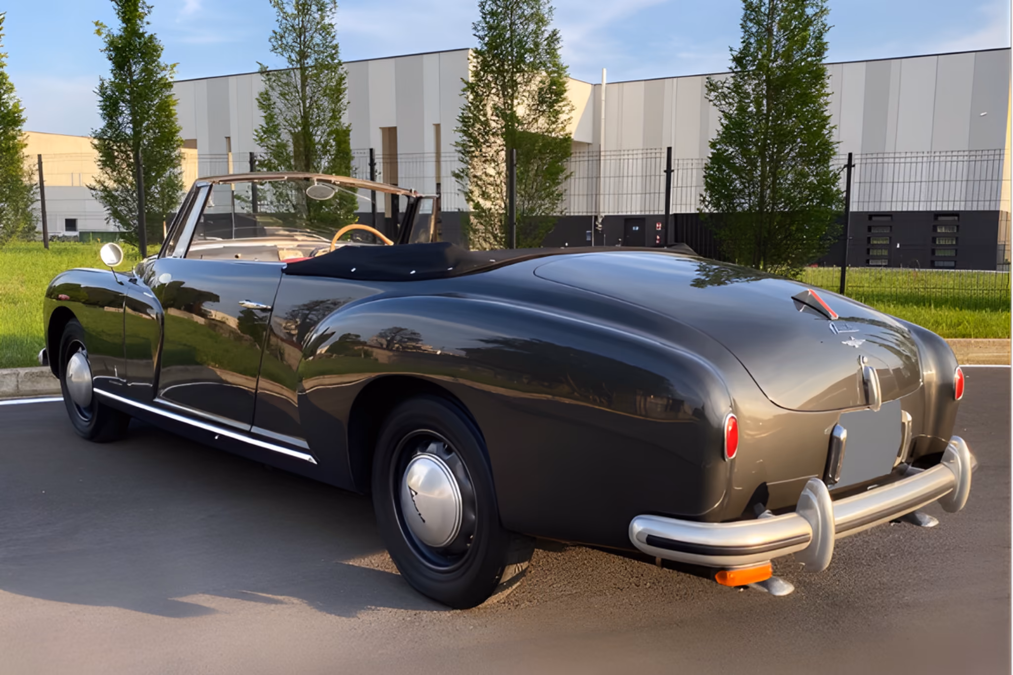 Rear exterior view of the Lancia Aurelia B50 with driver for ceremonial travel and formal occasions