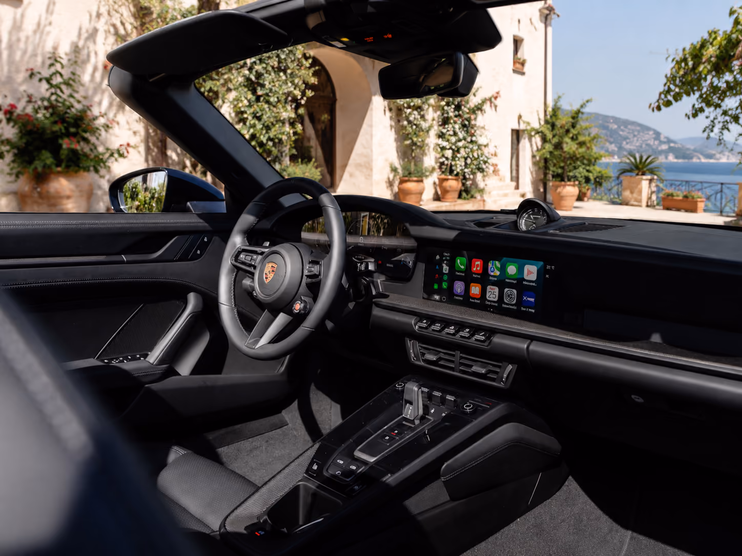 Open-top interior of a Porsche iconic convertible car with premium driver-focused cockpit