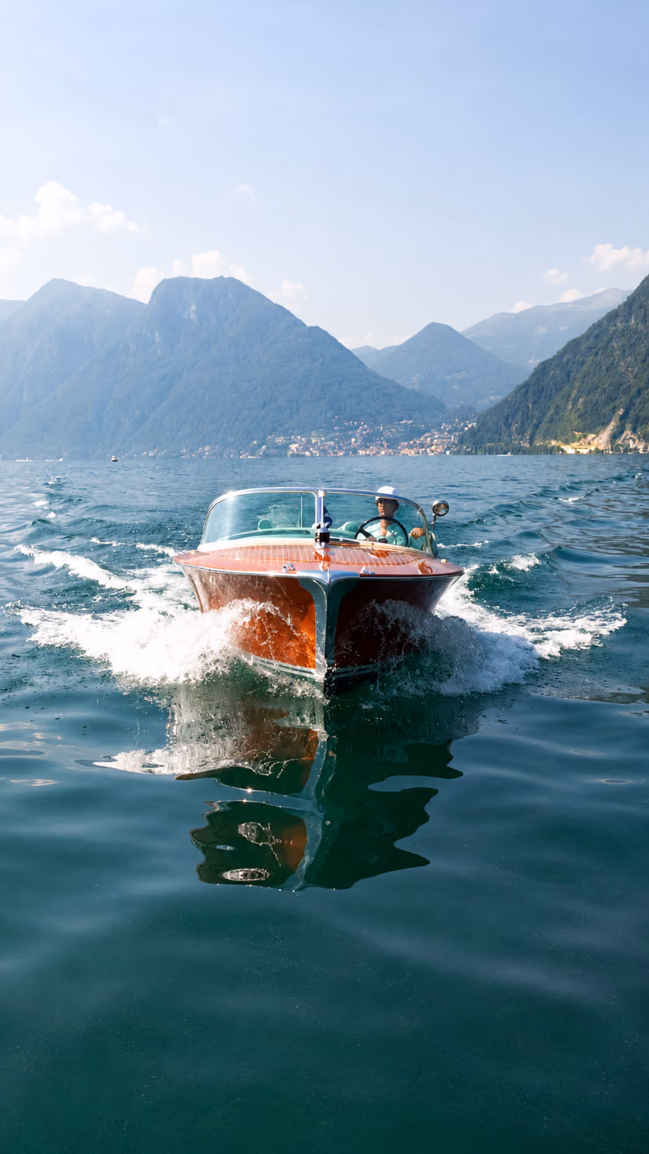 Riva boat cruising across Lake Como with scenic mountain views and premium onboard experience