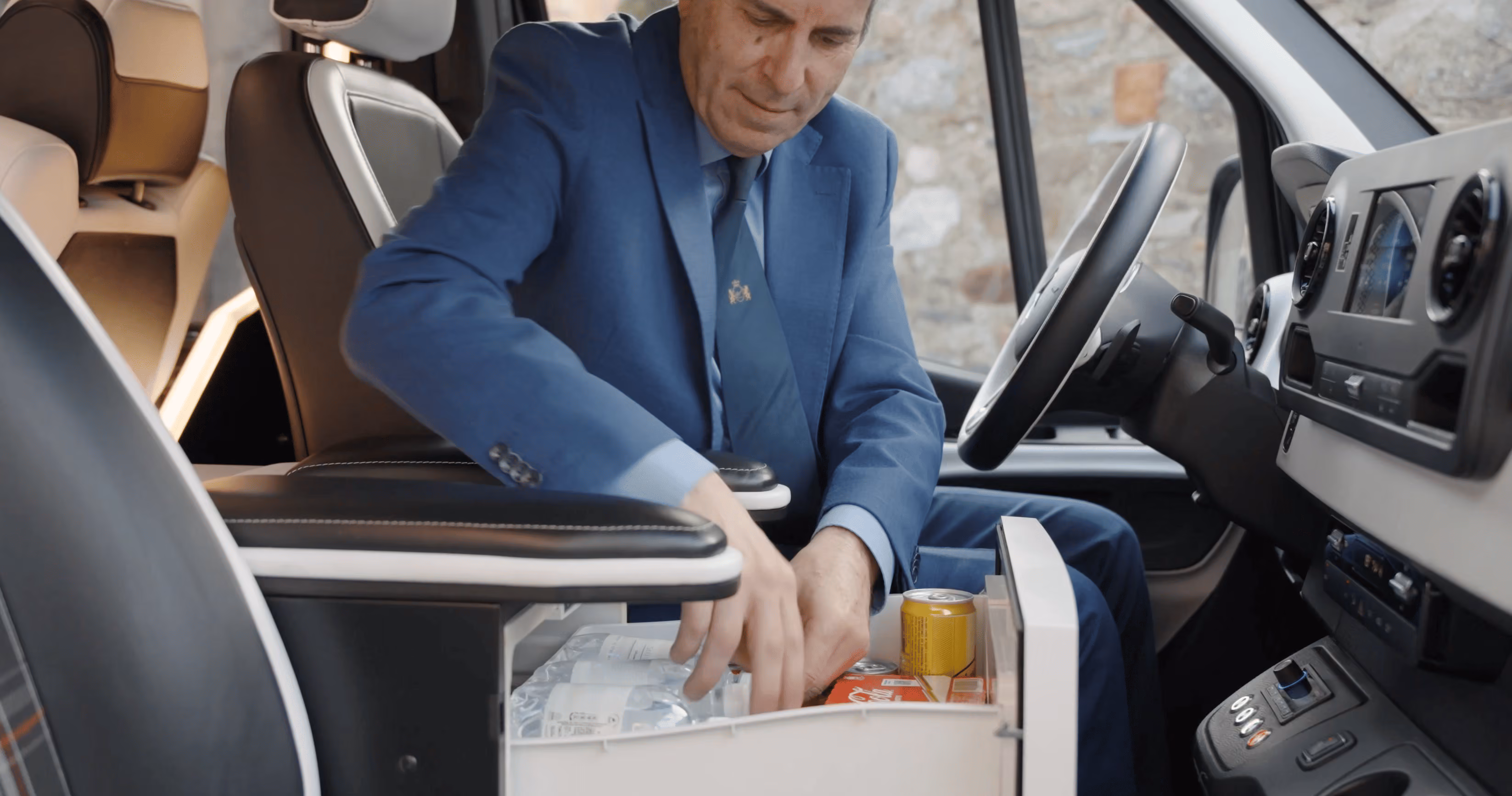 Chauffeur preparing onboard amenities inside the Moveolux Limovan Portofino