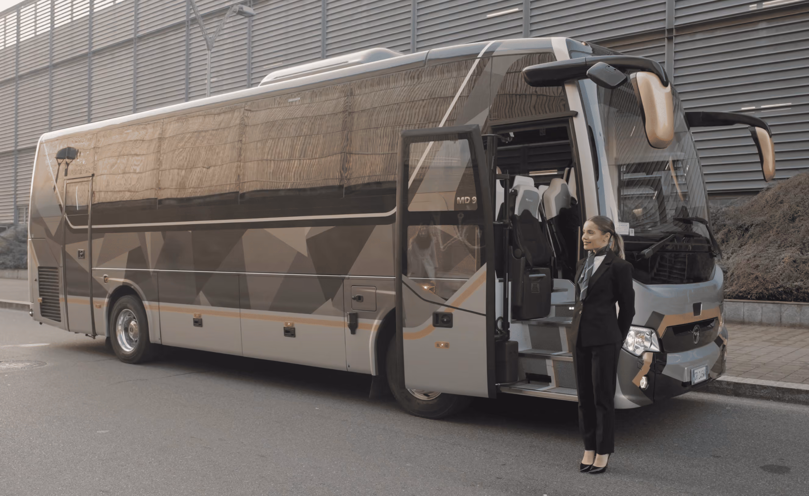 Exterior arrival view of the Moveolux Limobus Seabreeze 18 with hostess for private group service