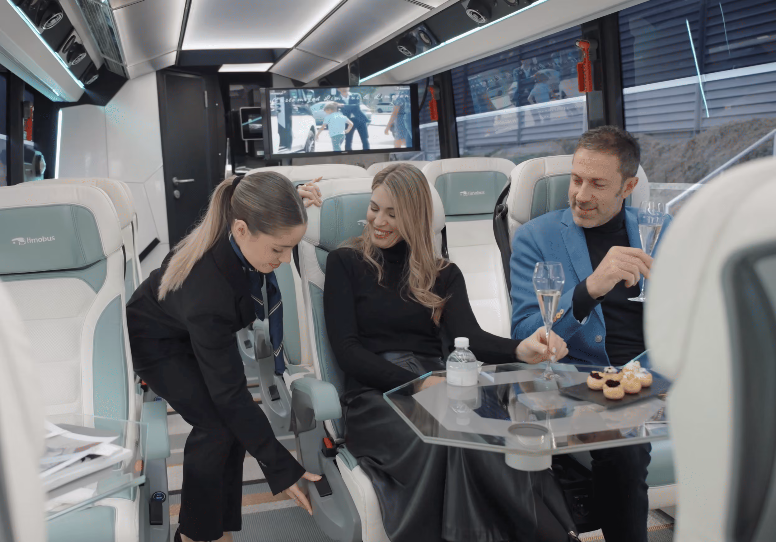 Onboard hostess service inside the Moveolux Limobus Seabreeze 18 during a premium group journey