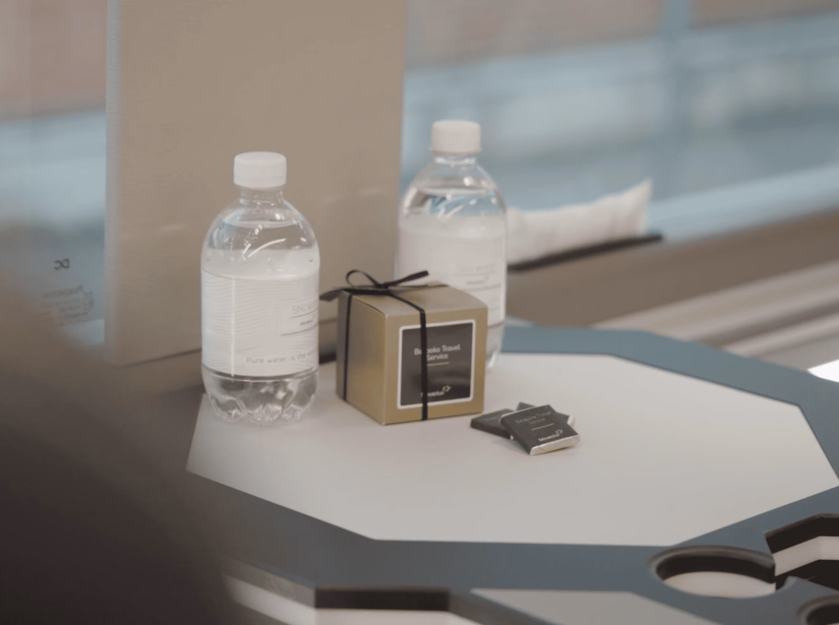 Table service detail inside the Moveolux Limobus Elements 20 with bottled water and amenities