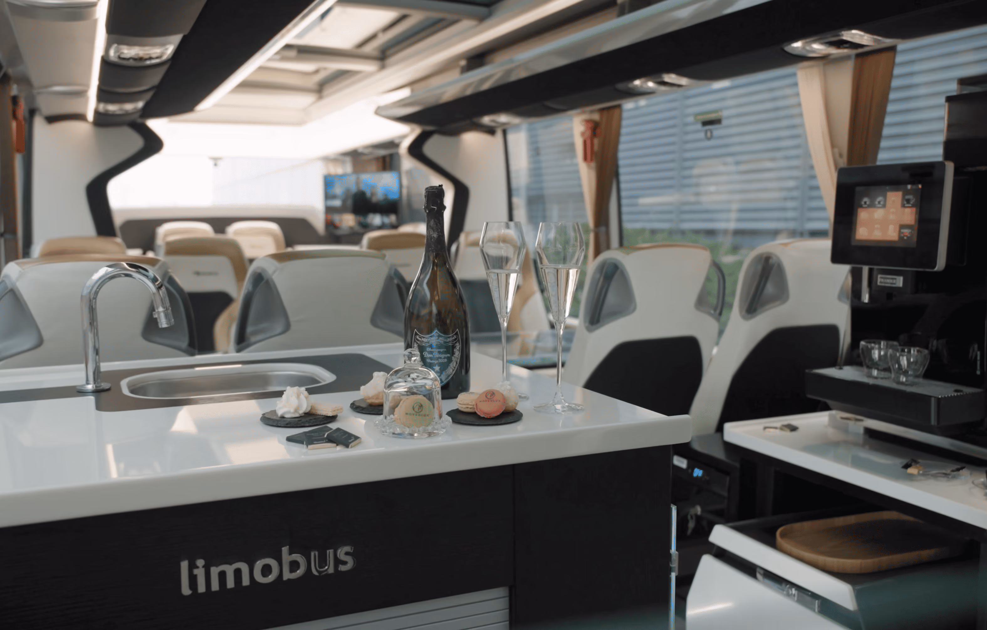 Lounge table and screen inside the Moveolux Limobus Individuals 28 for premium onboard meetings