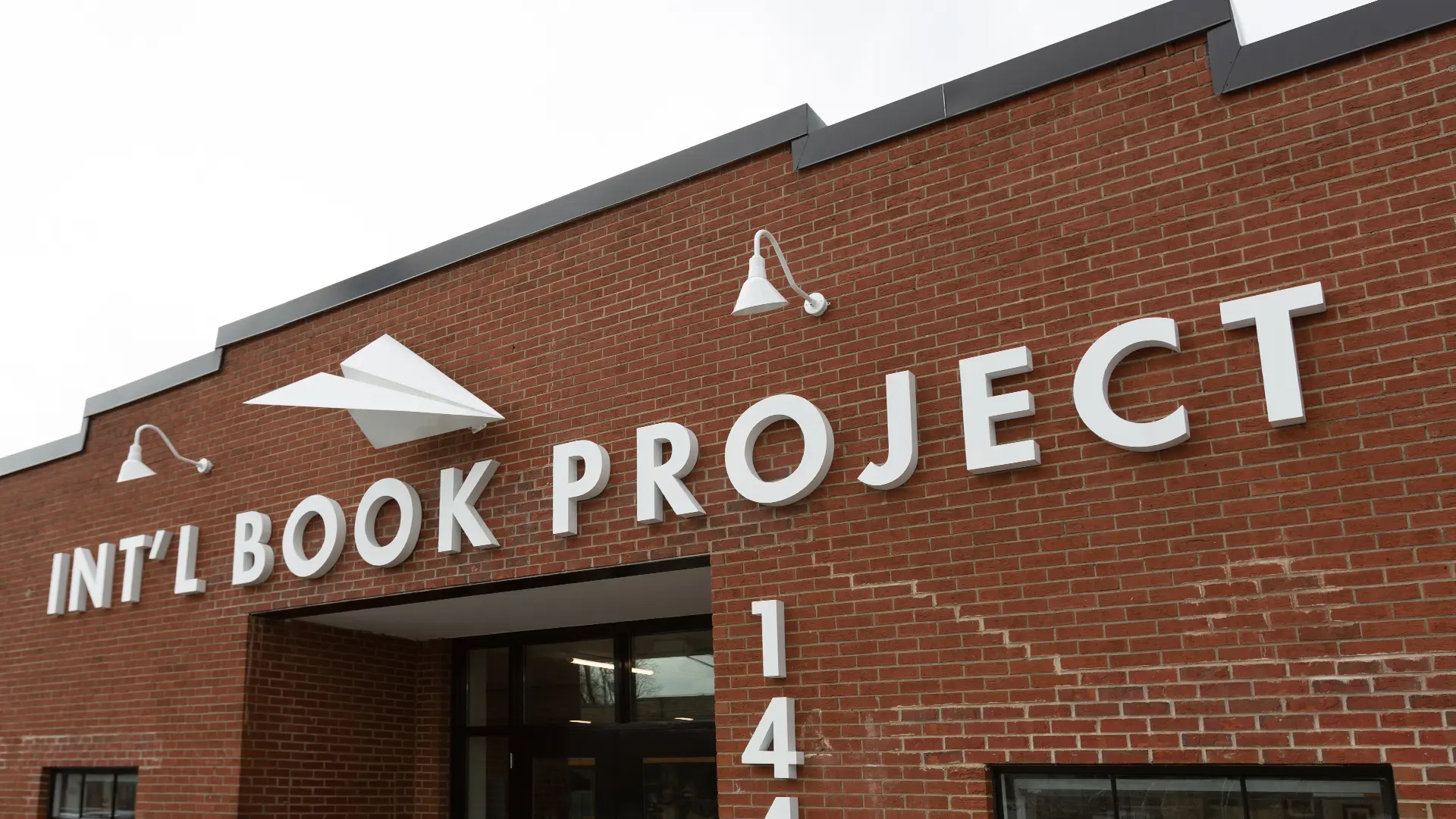 Exterior of a brick building with an International Book Project sign