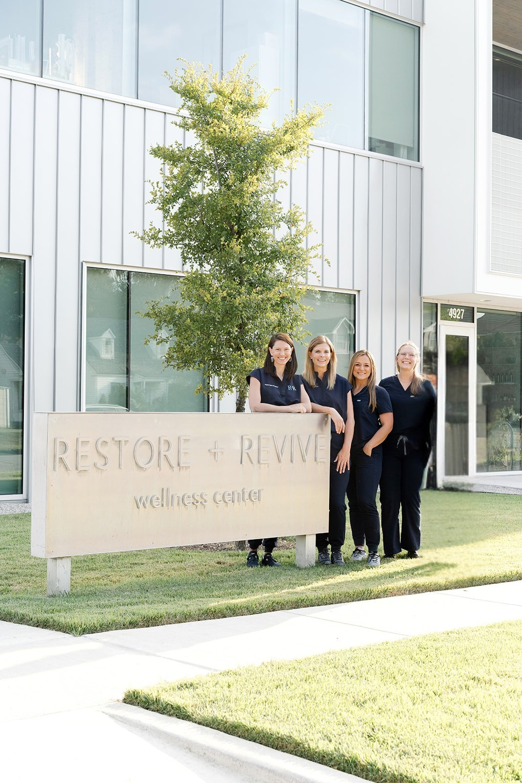 restore + revive team gathered near front entrance exterior sign