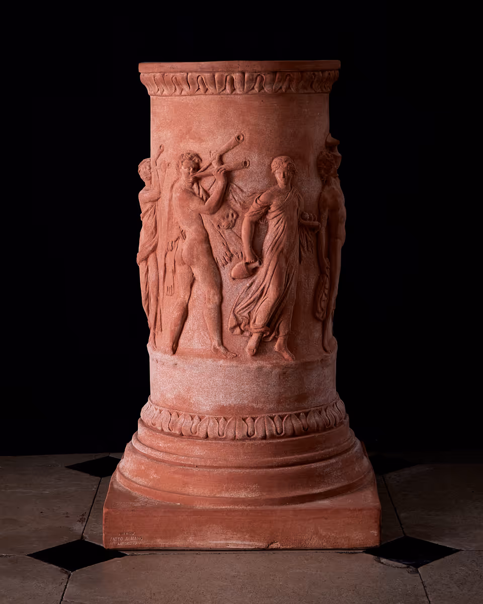 Portraying a dynamic Bacchanalian procession, the Colonna Greca Antica balances classical festivity with the strength of Impruneta clay.