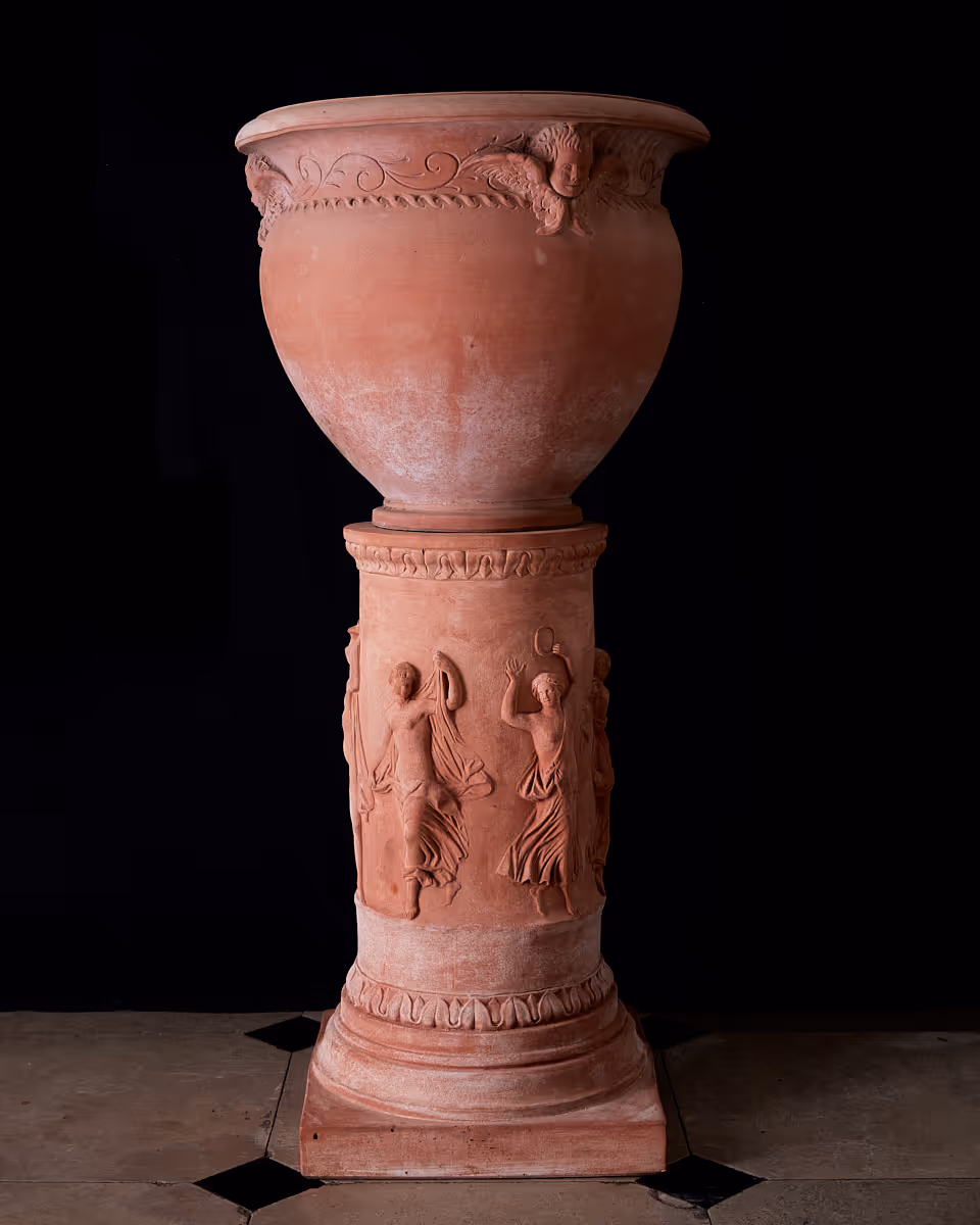 Portraying a classical krater adorned with Renaissance cherubim, the Crateri con tre angeli balances celestial grace with Impruneta clay.