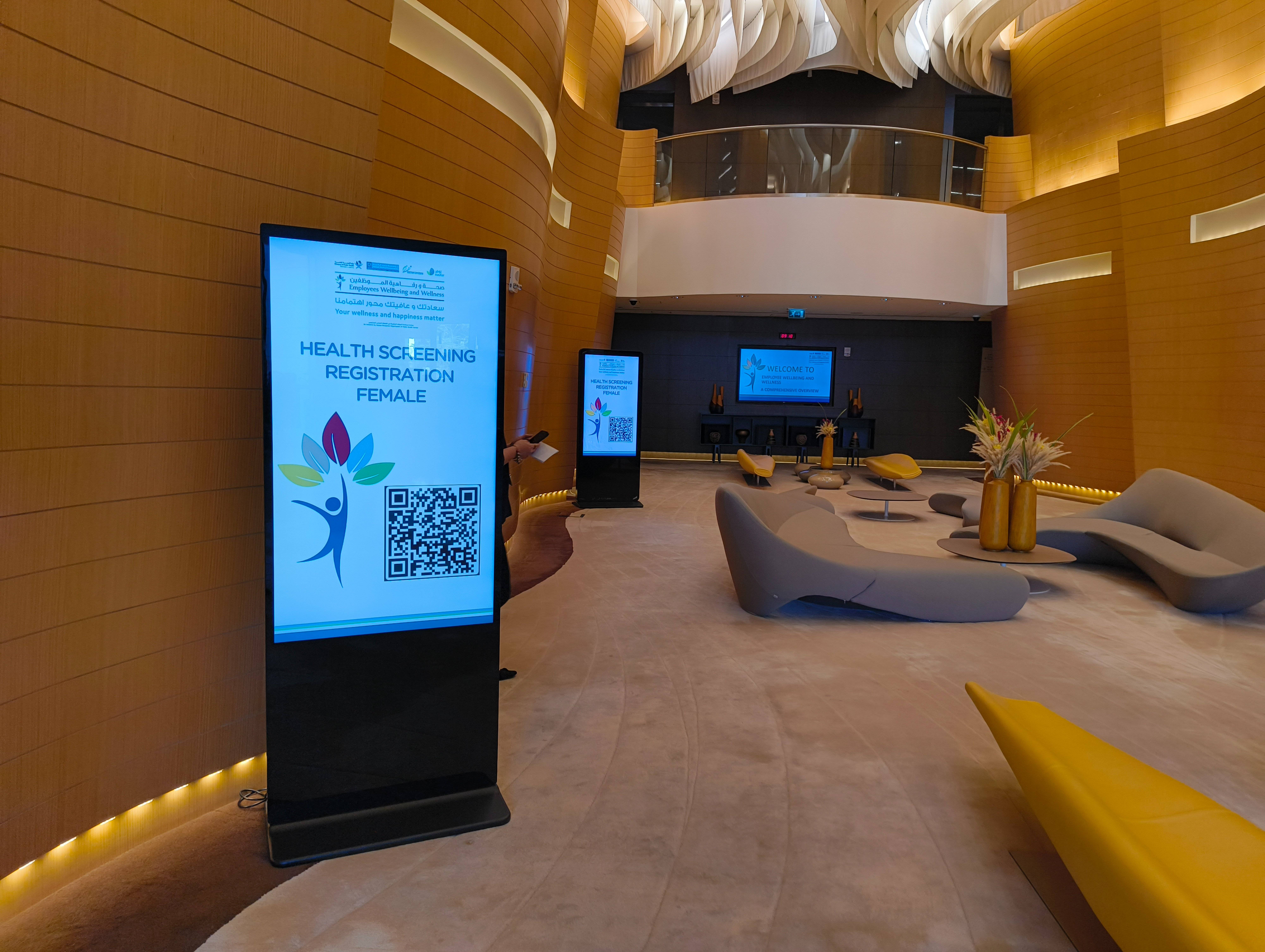 Digital signage kiosk with health screening QR code registration in hotel lobby, ELV solutions by Technobriq