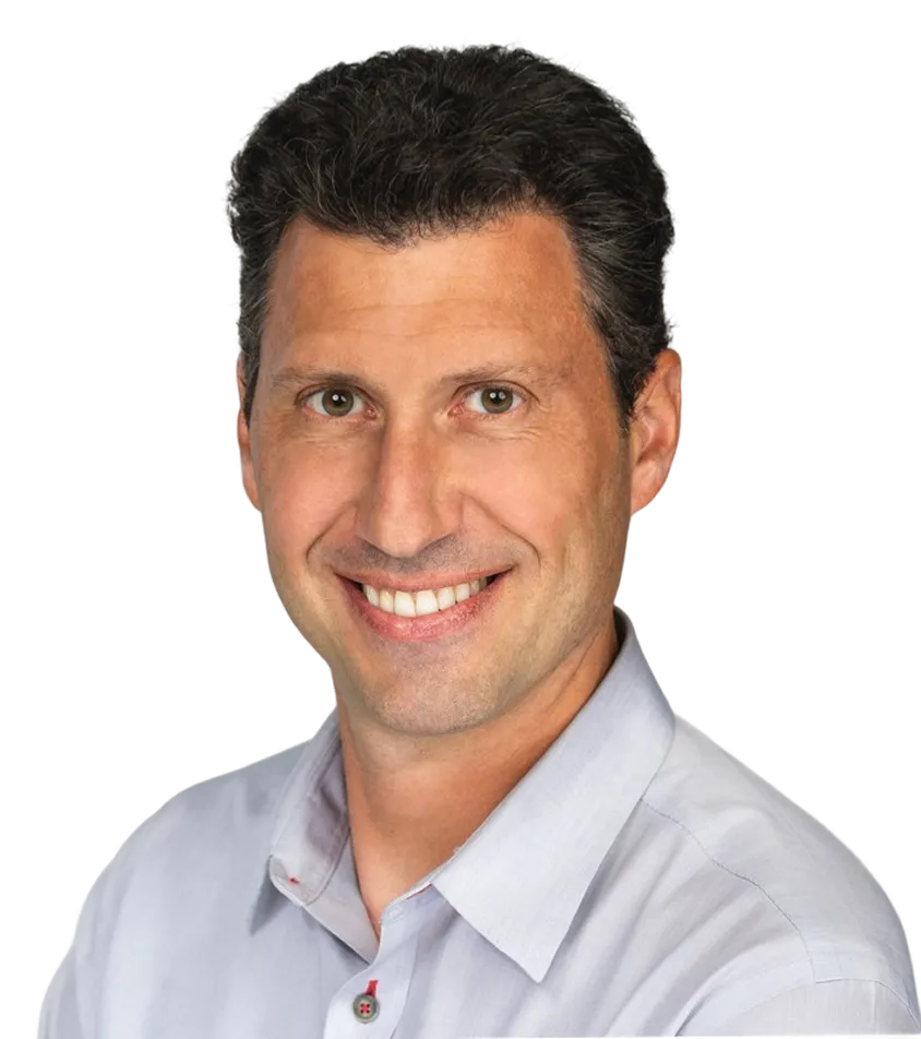 Smiling man with short dark hair wearing a light gray button-up shirt.