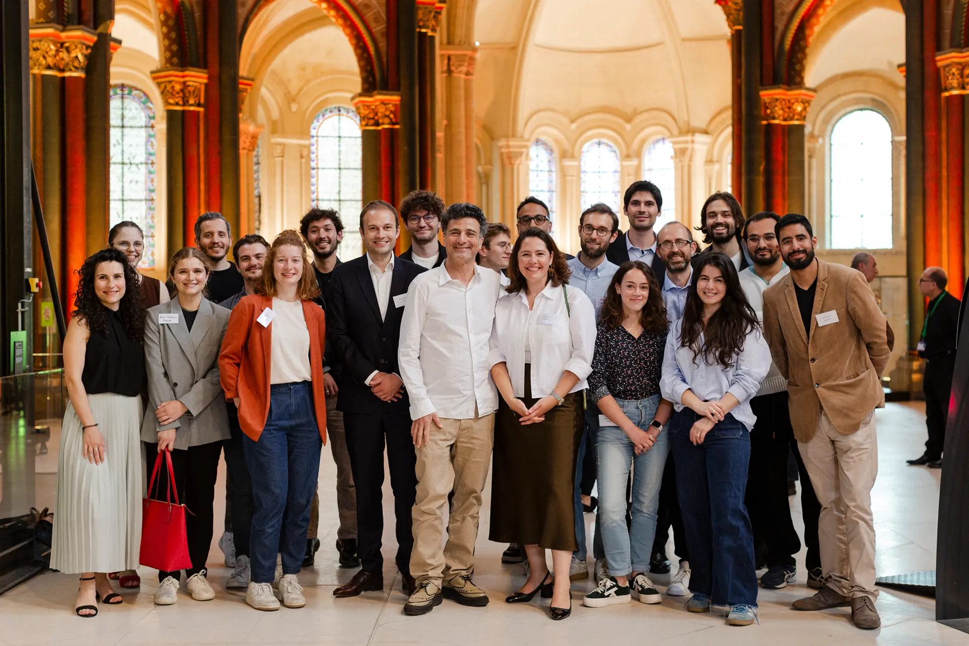 The whole team of 21 people standing in a fancy room
