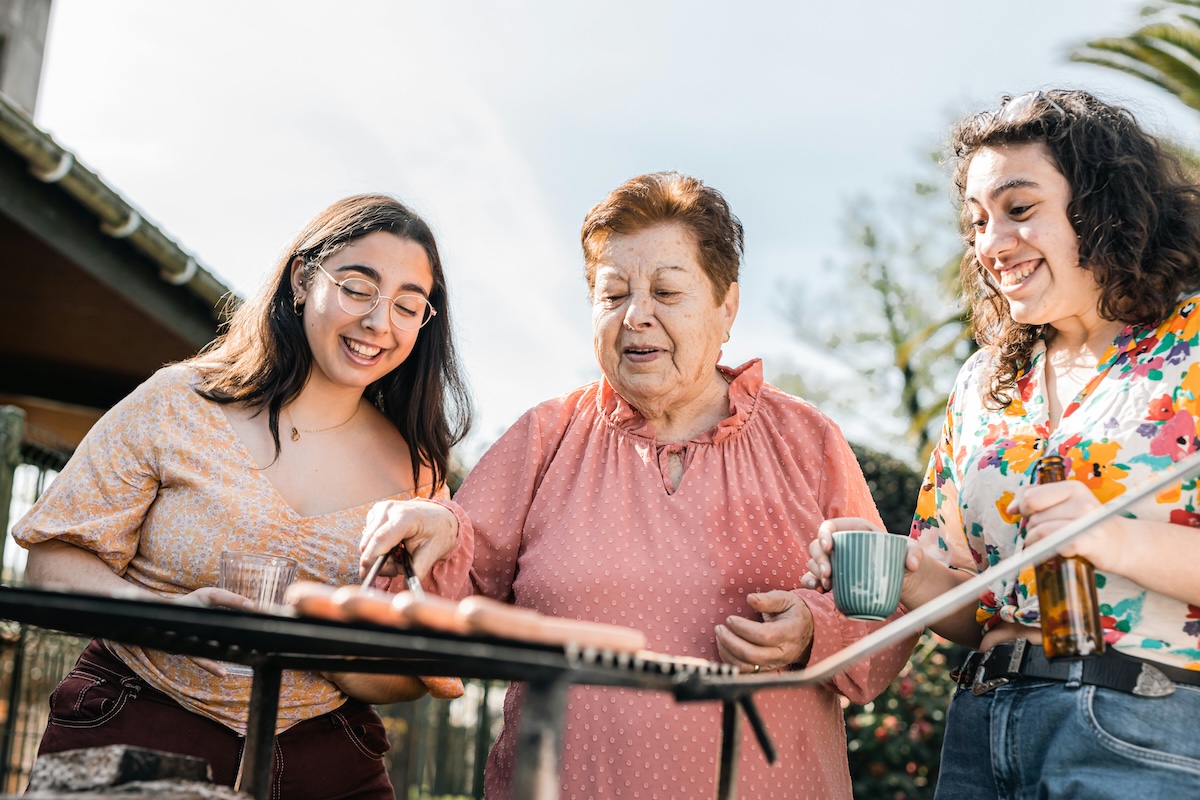 Two generations of family enjoying grilling outside. 